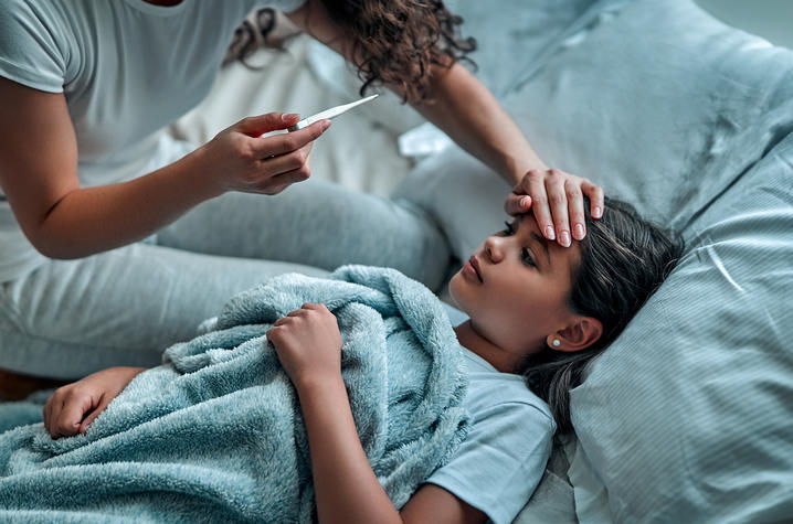 Mother taking daughter's temperature