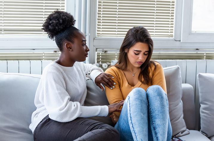 Image of young woman comforting sad friend 