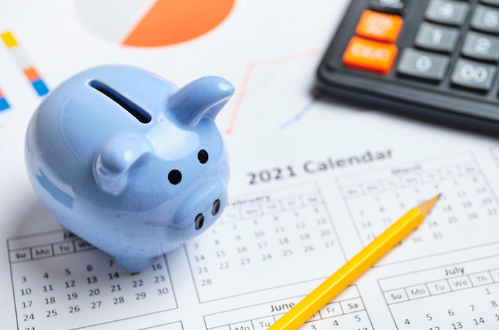 blue piggy bank, calendar and calculator with pencil