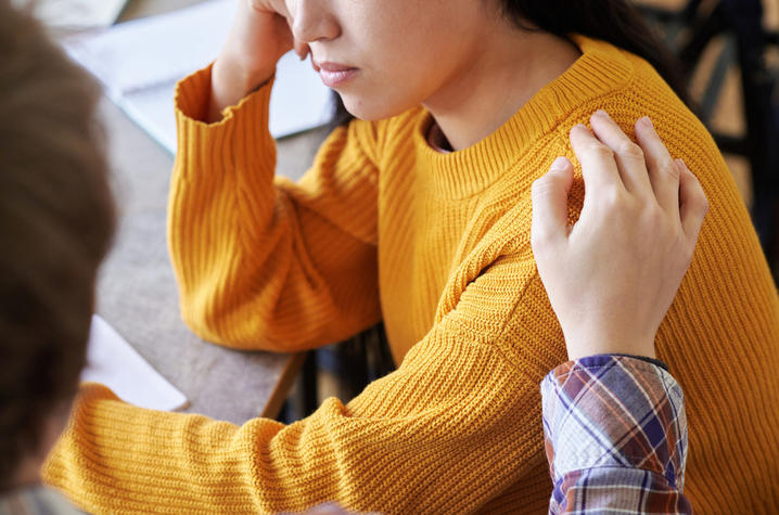 A consoling hand on a shoulder
