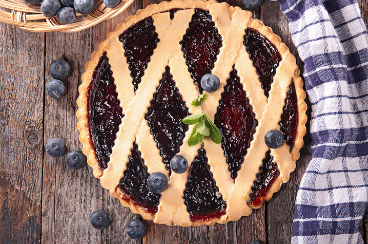 photo of blueberry pie with blueberries on top and to side