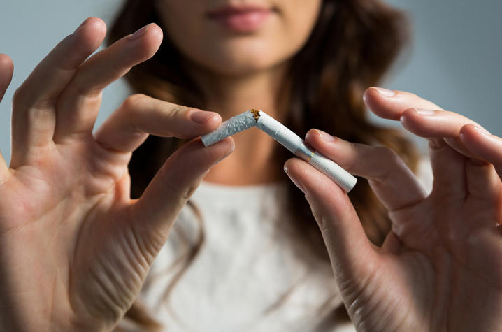 photo of woman breaking cigarette in half