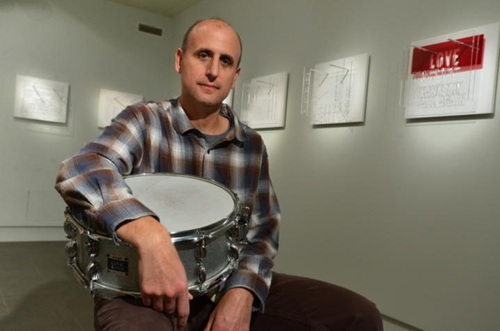 photo of Michael Gould with drum at exhibit