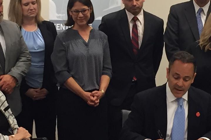 photo of Katie Wolf Whaley watching while the Governor signed the executive order