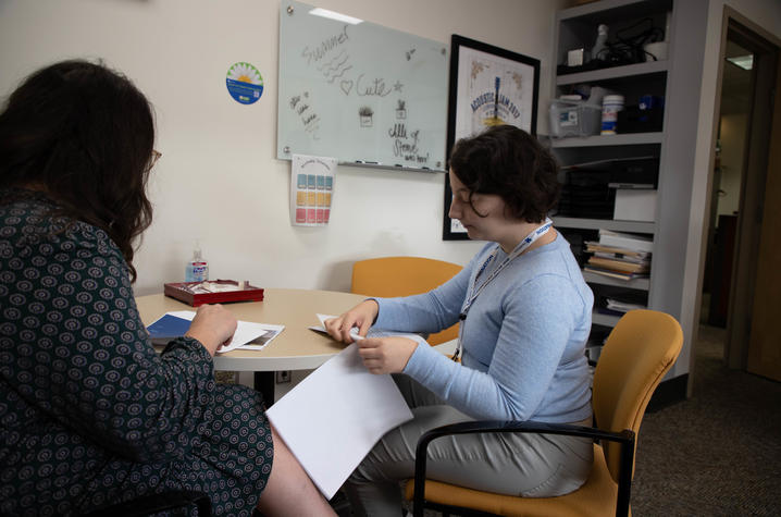 A student flips through a packet of information at a desk within hospital administration at Kentucky Children's Hospital.