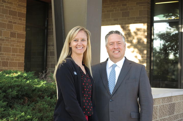 Photo of woman with blonde hair standing next to man with gray hair outside a building