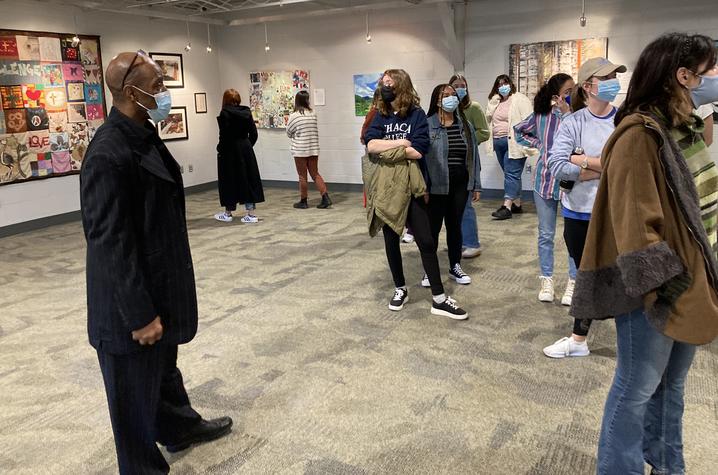 photo of Whit Whitaker (far left) with AAD 390 students looking around art gallery at The Lyric