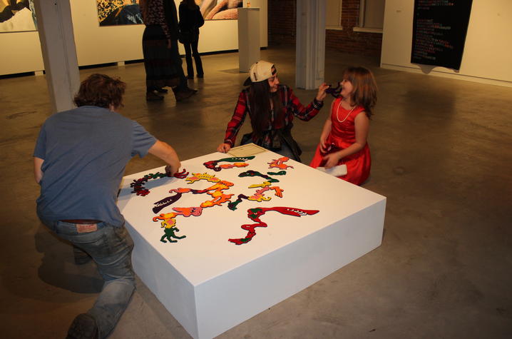 photo of group looking at student artwork at Carey Ellis Juried Art Exhibition