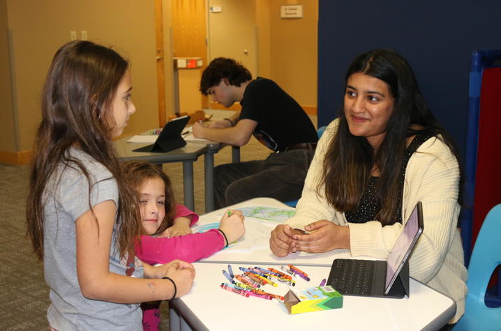 Tharanie Subramaniam, a computer engineering major, works with students at the Lexington Public Library for her CIS 122 project explaining how the internet works.
