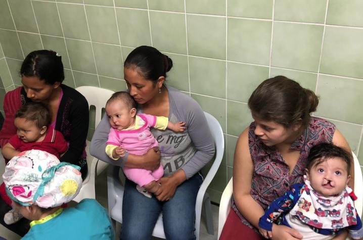 Photo of women with their children awaiting surgery screening