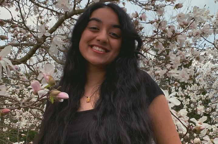 headshot photo of Isha Chauhan next to tree in bloom