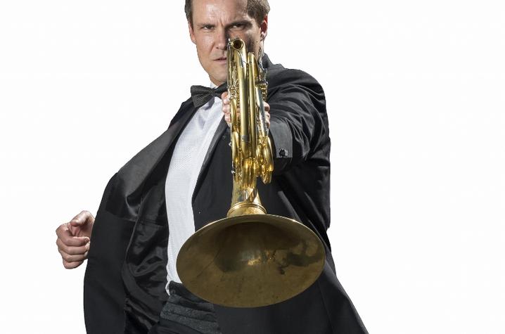 photo of Jeff Nelsen holding French horn in James Bond pose