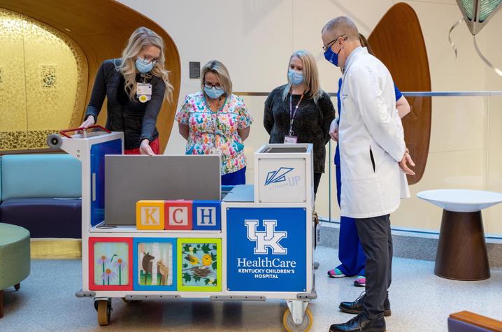 Image of KCH staff looking at transport cart