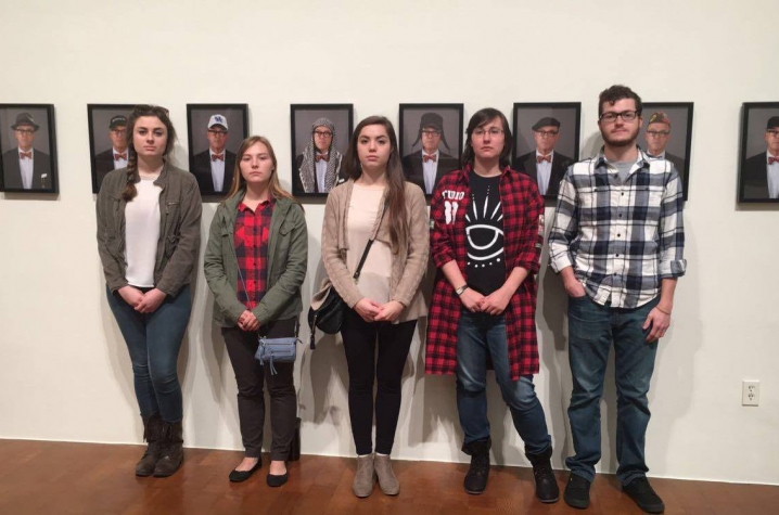 photo of operations team from "Art Entrepreneurship" class with portraits from "Saving Myself" by Louis Zoellar Bickett