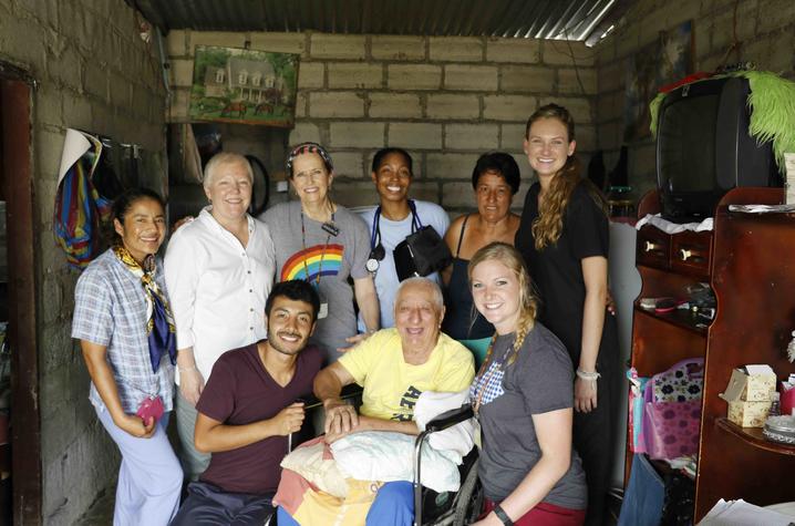 Group of volunteers and community members gathered inside a home for a photo.