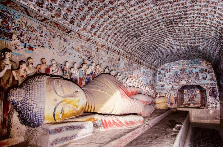 photo of Buddha sculpture on side at Mogao grottoes 