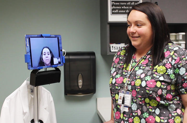 A nurse interacts with the video remote interpreter