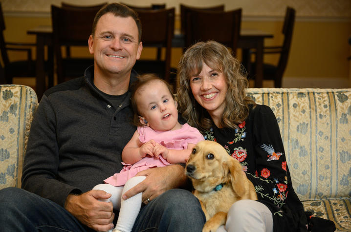 Image of Wylie on sofa with parents and dog