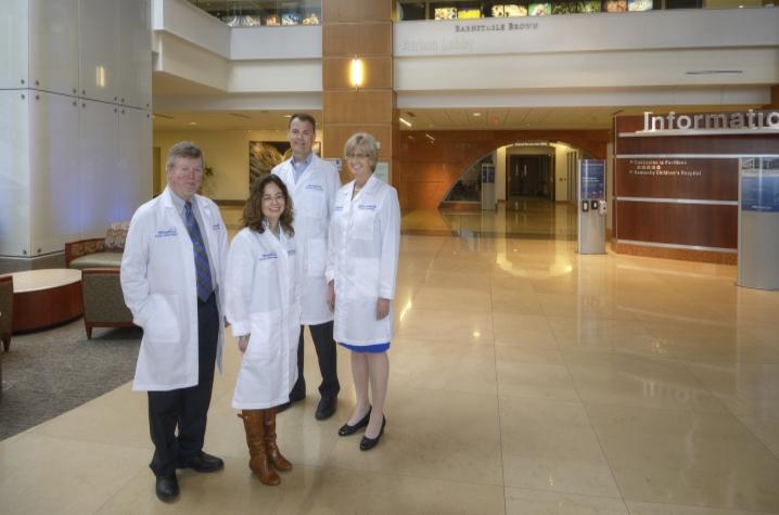 Four people standing in atrium