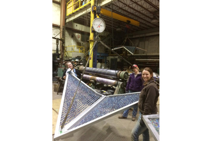 Photo of fabrication team with large blue kite