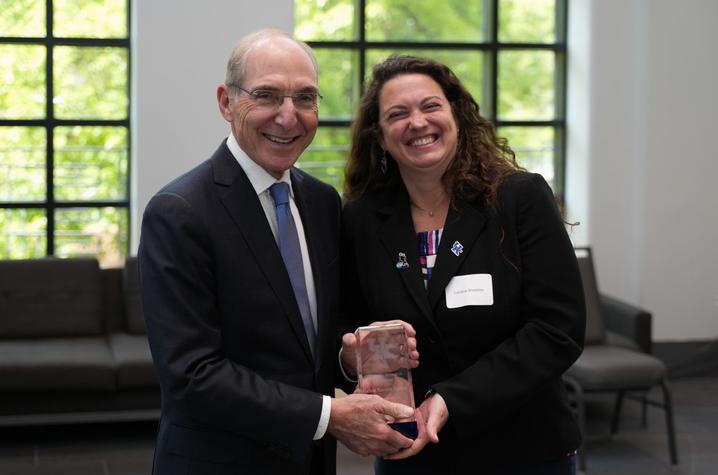 Luciana Shaddox standing with President Capilouto smiling at the university research professorship ceremony