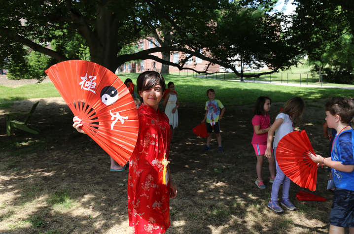 photo of kid with fan dressed in traditional Chinese clothing