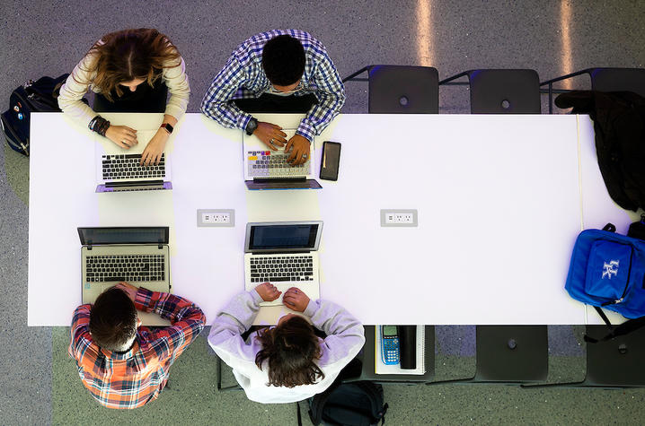 People sitting, working on laptops