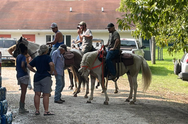 image of volunteers delivering supplies on horseback