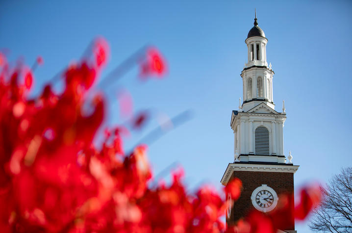 photo of Memorial Hall spire with bright red fall leaves in the foreground