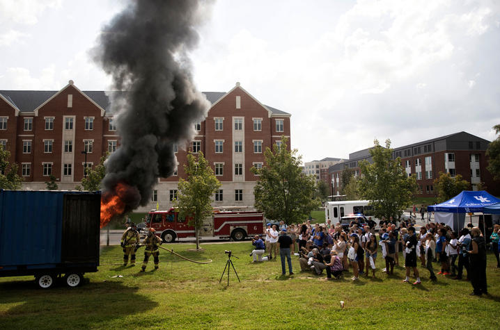 photo of people watching fire demonstration of how quickly a residence hall room can catch fire