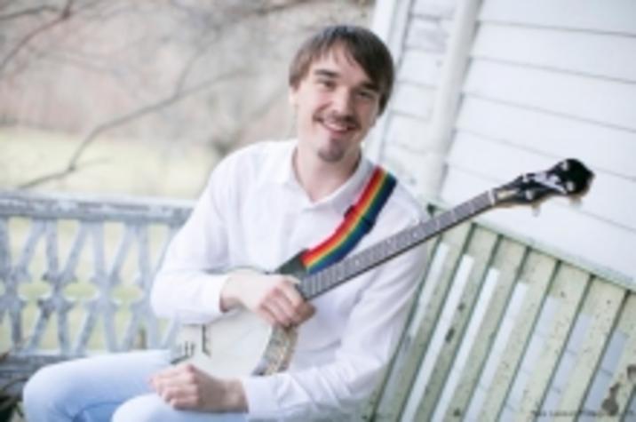 photo of Sam Gleaves seated on porch with banjo