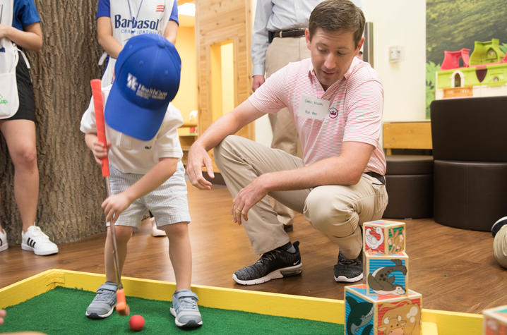 PGA golfer Chris Wilson and young patient play mini golf