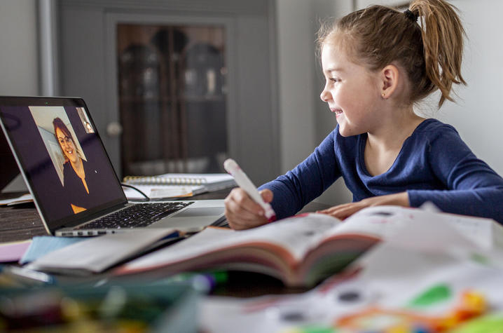 Young girl working with a virtual tutor. 