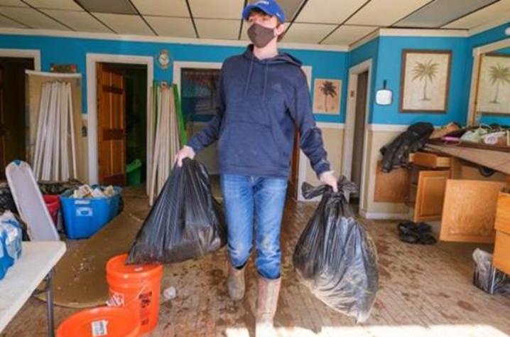 Ty Cheatham, AGR Fraternity member and a freshman agricultural and medical biotechnology major from Adair County, removes trash from a building in downtown Beattyville on March 5.