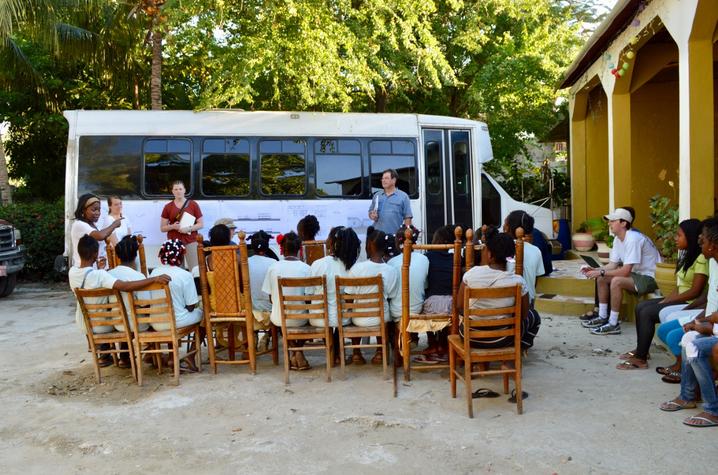 photo of students and Bruce Swetnam presenting plans for Haiti orphanage