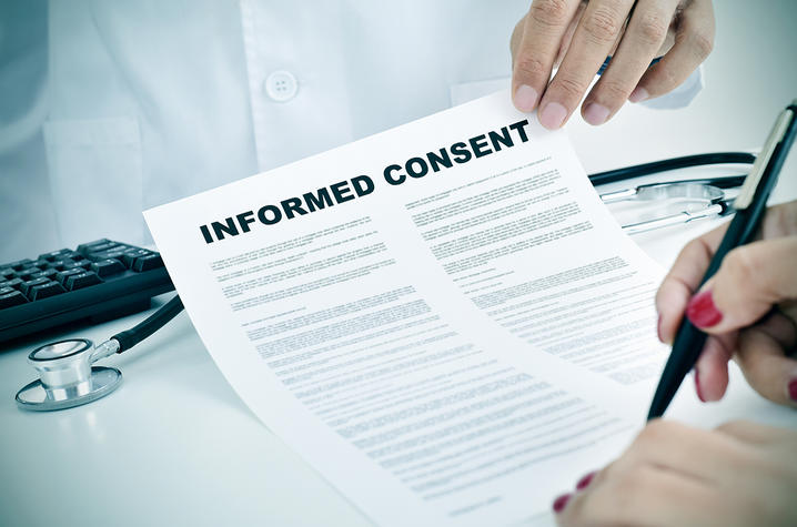 A woman signs an informed consent document