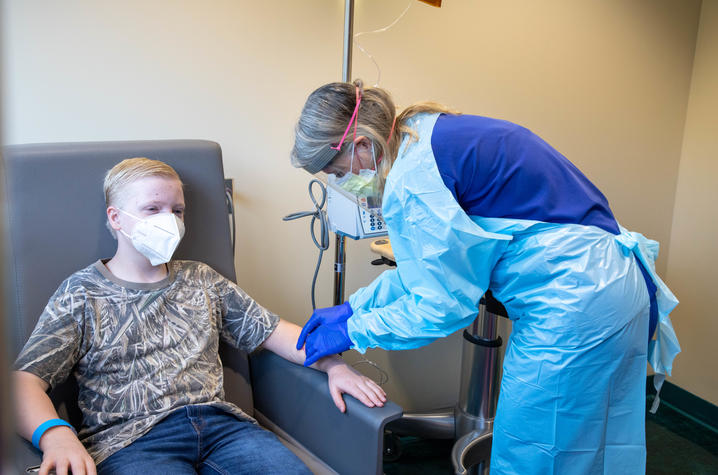 image of nurse in protective gear demonstrating an IV infusion