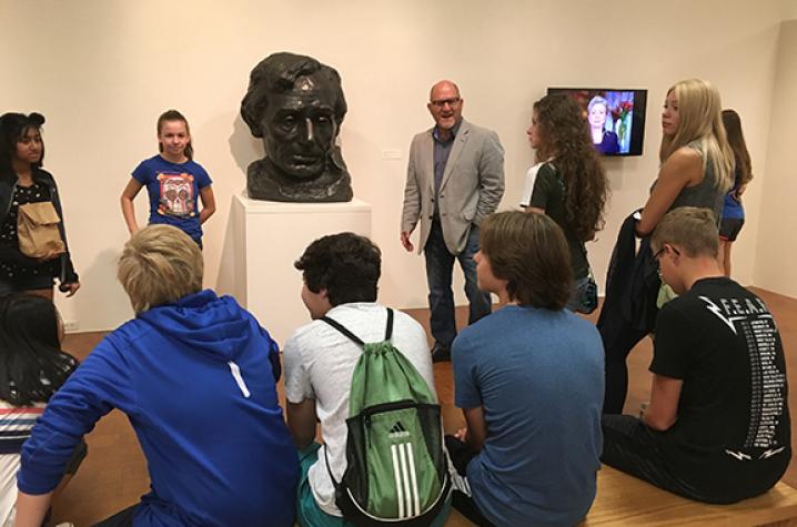 Stuart Horodner, standing next to a bust of Abraham Lincoln by Gutzon Borgulm, leads high schoolers on "POTUS" tour
