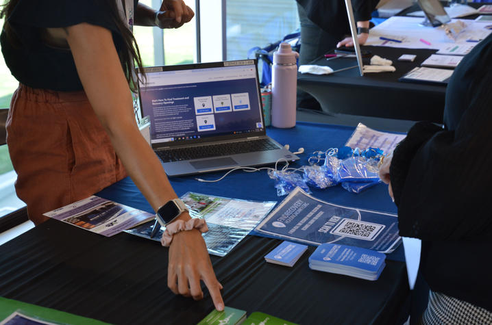 Someone explains resources at a tabling event.