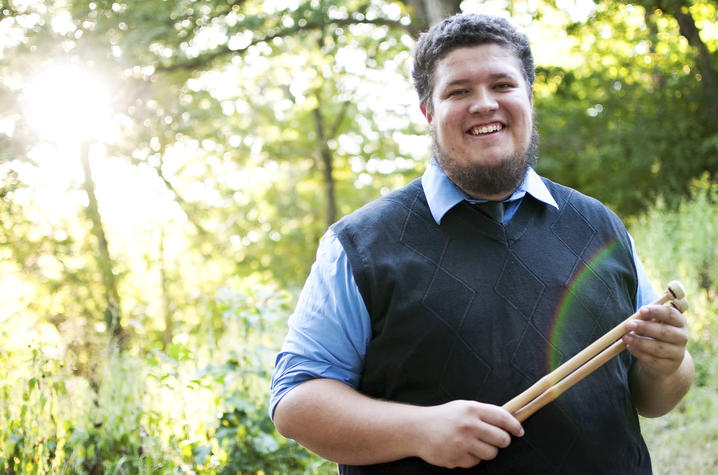 photo of Tyler Swick holding drumsticks outside