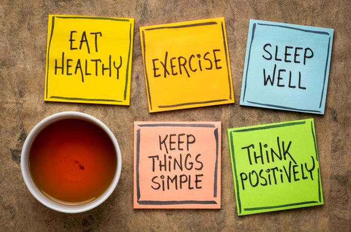 photo that shows post-it notes that say eat healthy; exercise; sleep well; keep things simple; think positively.  They are setting by a cup of tea.