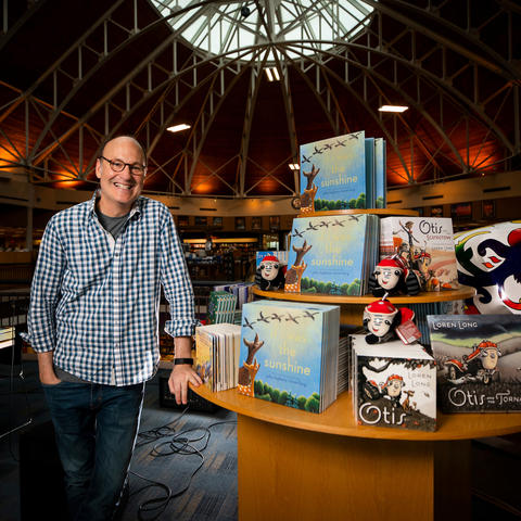 photo of Loren Long beside a table display of his books at Joseph-Beth
