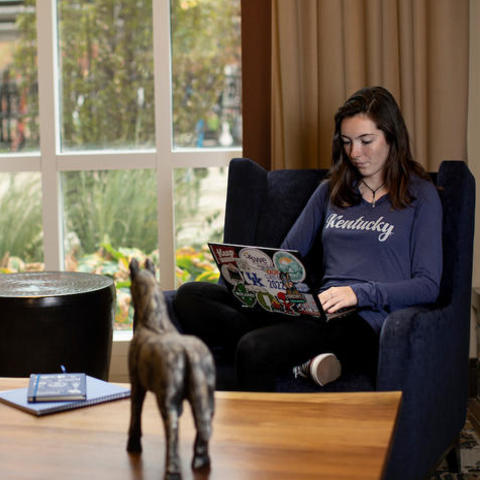 photo of student in recliner on laptop