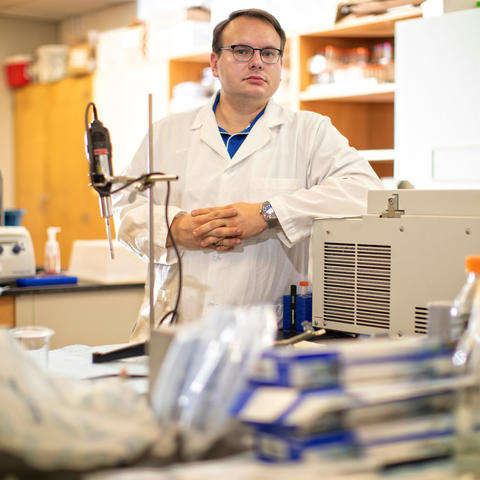Stuart Lichtenberg in lab coat behind lab table