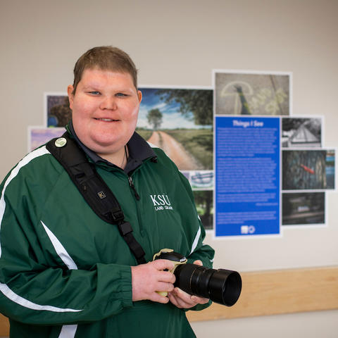 Photo of Chris Lyons with camera in front of gallery