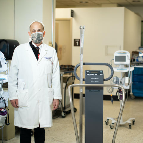 Principal Investigator Dr. Richard Greenberg and CCTS Clinical Operations Director Linda Rice, BSN, RN, CCRC. They are standing in a clinic several feet apart and are wearing face coverings. 
