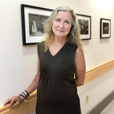 Photo of photographer Sarah Hoskins in front of exhibition