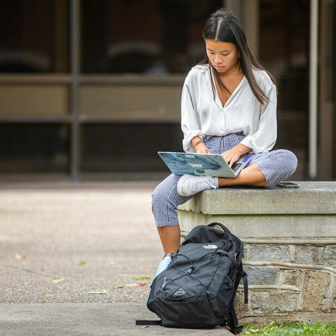 Photo of student studying on campus