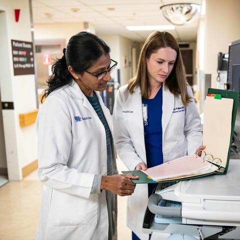 Dr. Padmaja Gaddam and Abby Pulliam look into a binder