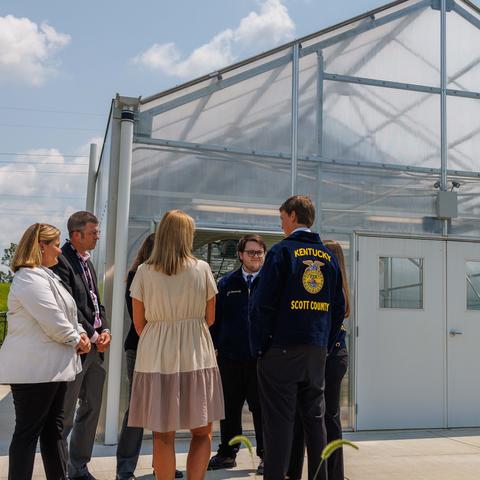 Students standing in front of a greenhouse